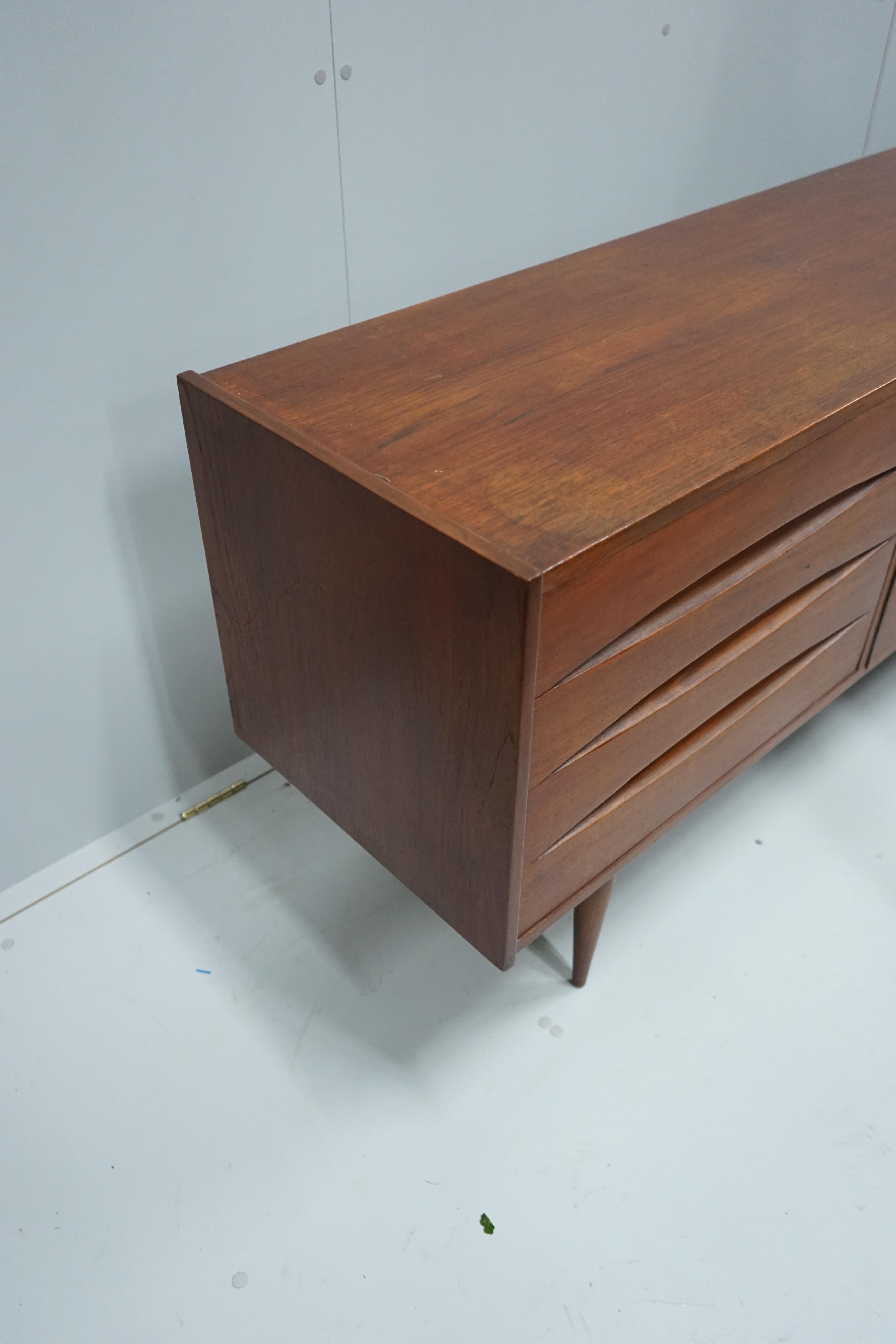 In the manner of Arne Vodder, a mid century teak sideboard width 221cm, depth 45cm, height 73cm.